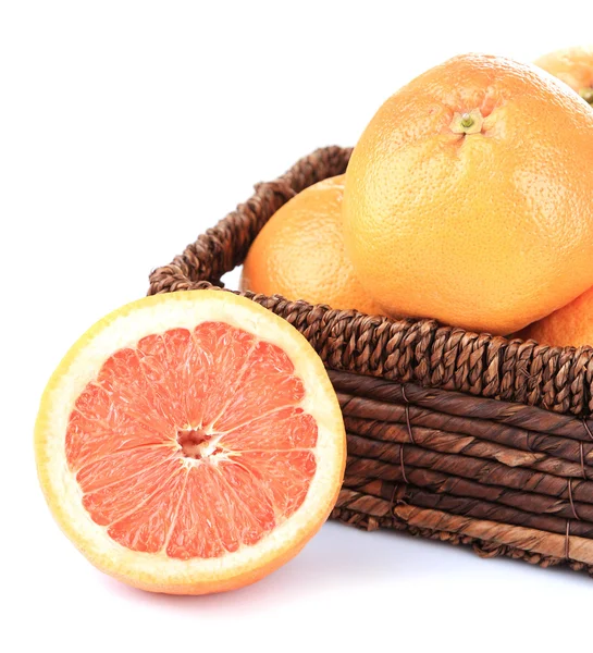 Rijp grapefruits in rieten mand geïsoleerd op wit — Stockfoto