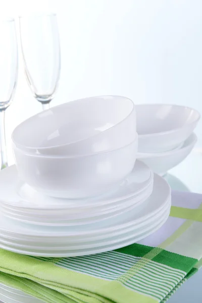 Set of white dishes on table on light background — Stock Photo, Image
