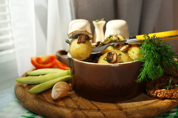 Las patatas jóvenes hervidas en la cacerola con hortalizas a la mesa en la cocina — Foto de Stock