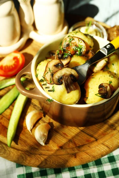 Jeunes pommes de terre bouillies dans une casserole avec légumes sur la table dans la cuisine — Photo