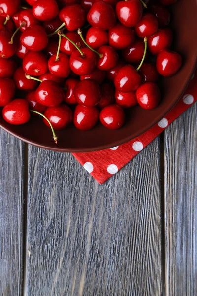 Sweet cherries  on plate on wooden background — Stock Photo, Image