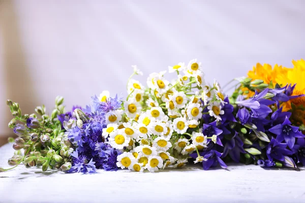 Beautiful wild flowers on wooden background — Stock Photo, Image