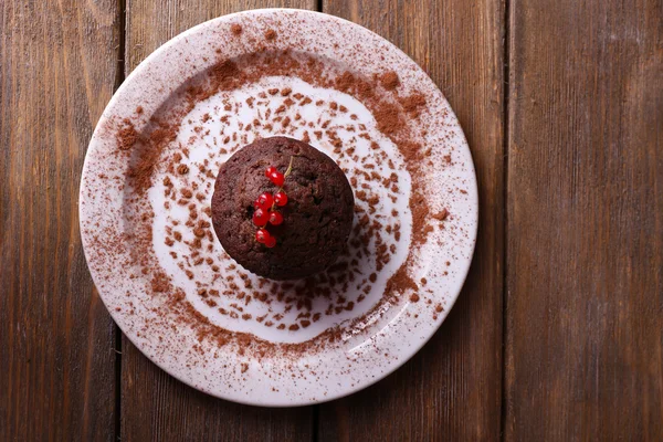 Čokoládový muffin s červeného rybízu na štítku na dřevěné pozadí — Stock fotografie