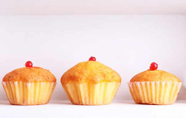 Tasty muffins on wooden shelves, close-up — Stock Photo, Image