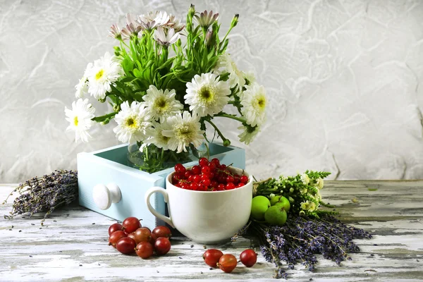 Still life with flowers and fruits on table — Stock Photo, Image