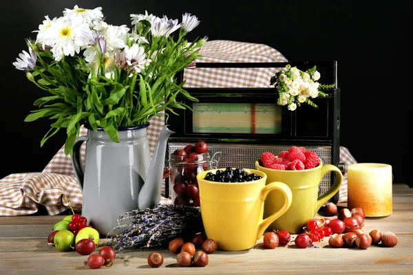 Still life with flowers and fruits on dark background — Stock Photo, Image