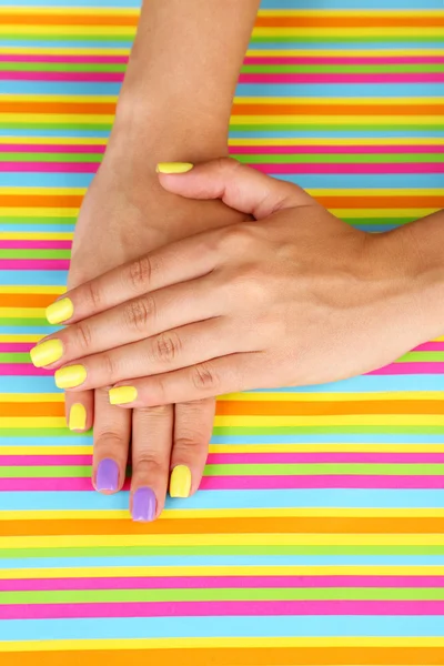 Mano femminile con unghie colorate alla moda, su sfondo luminoso — Foto Stock