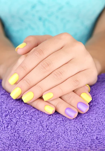 Mão feminina com unhas coloridas elegantes, na toalha de cor, close-up — Fotografia de Stock