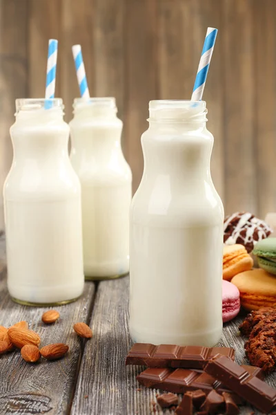 Milk in bottles with paper straws on table — Stock Photo, Image