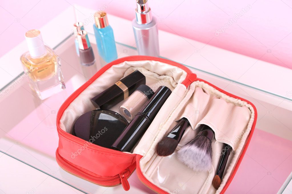Cosmetic bag on table on light  pink background