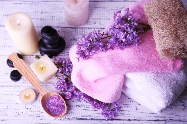 ışık arka plan üzerinde spa tedavisi, havlu ve eflatun çiçekler ile kompozisyon