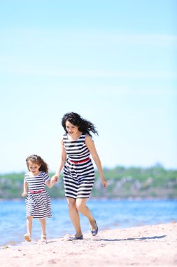 mutlu anne ve kızı. Sahilde yürüyüş