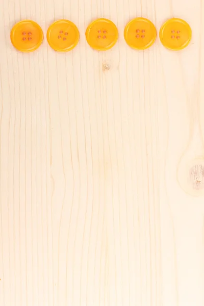 Барвисті швейні гудзики на дерев'яному фоні — стокове фото