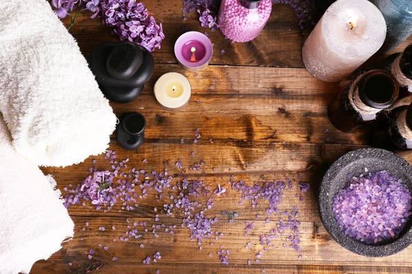 Composition with spa treatment, towels and lilac flowers, on wooden background — Stock Photo, Image