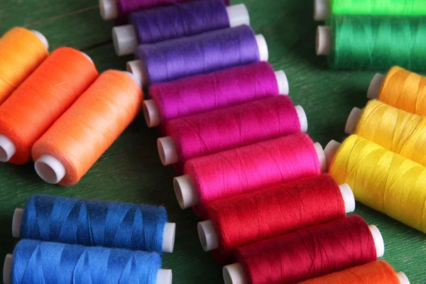 Filati per cucire multicolore su fondo di legno — Foto Stock