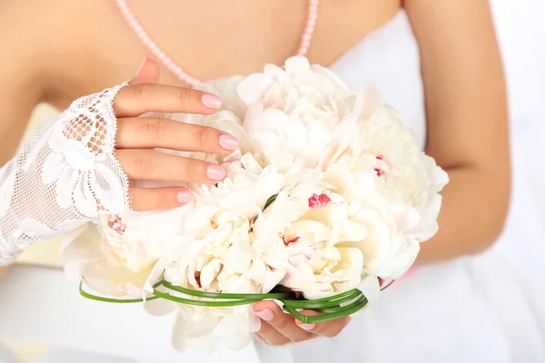 Menyasszony kezében esküvői csokor fehér pünkösdi rózsa, zár-megjelöl, a világos háttér — Stock Fotó