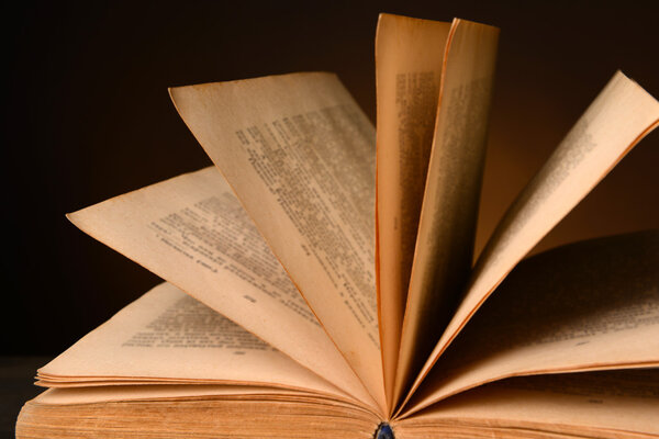 Старая книга на столе на коричневом фоне
