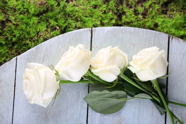 Belas rosas brancas na mesa de madeira — Fotografia de Stock