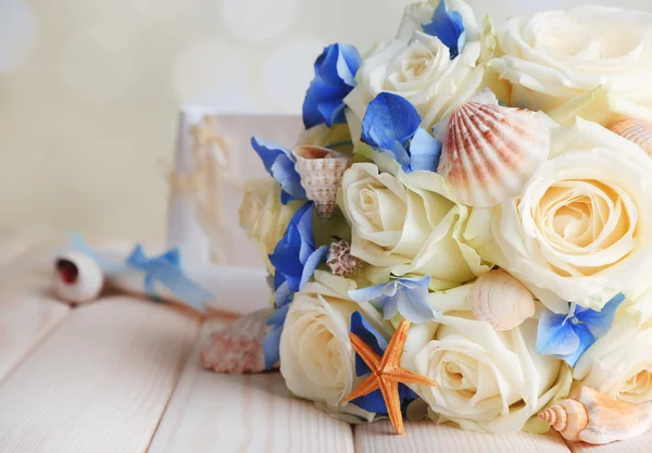 Beautiful wedding bouquet with sea decor on wooden table — Stock Photo, Image