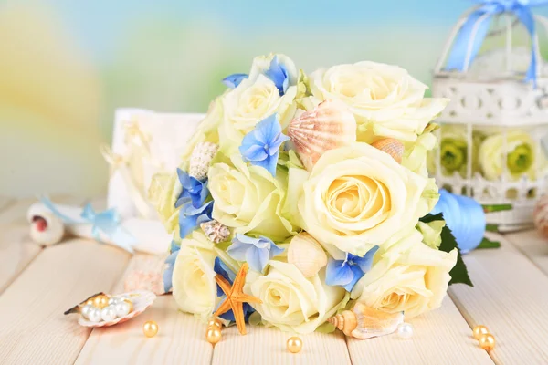 Красивый свадебный букет с розами на деревянном столе, на фоне природы — стоковое фото