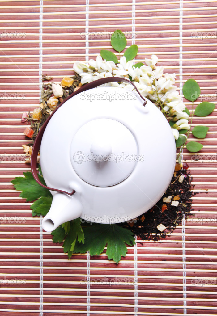 Herbal natural floral tea infusion with dry flowers and herbs ingredients, on bamboo mat background