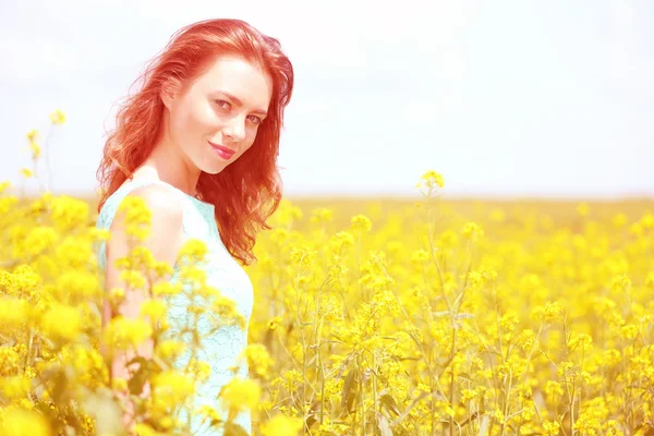 Beautiful young woman in flower field — Stock Photo, Image