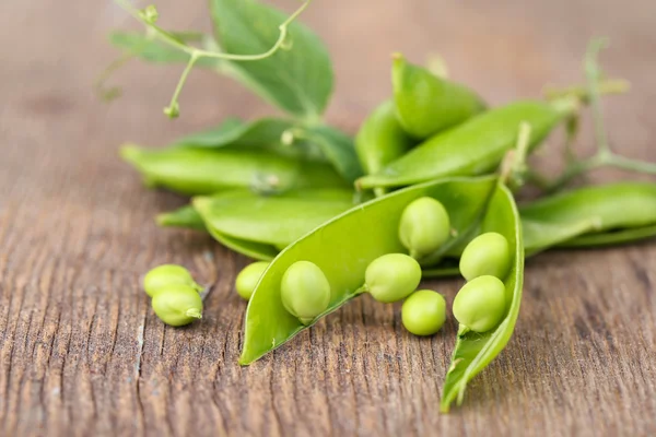 木のテーブルの上に新鮮な緑のエンドウ豆 — ストック写真