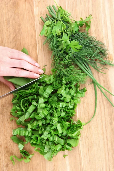 Female hand cutting greens on cutting board — Stock Photo, Image