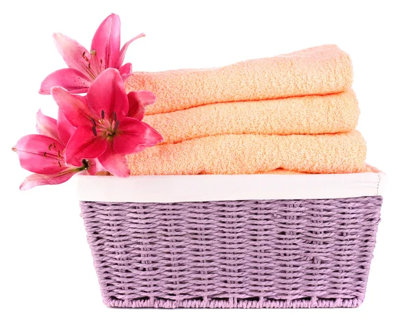 Color towels and lily flowers in wicket basket, isolated on white — Stock Photo, Image