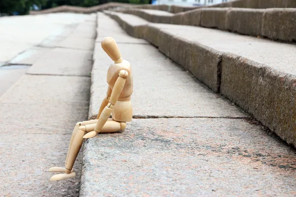 Marionnette pose en bois assise sur l'escalier, à l'extérieur — Photo