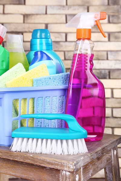 Чистящие средства на полке на фоне стен из кирпича
