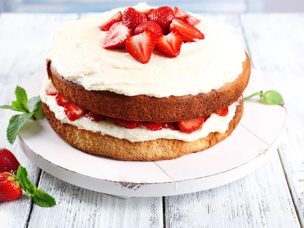 Delicious biscuit cake with strawberries on table close-up — Stock Photo, Image