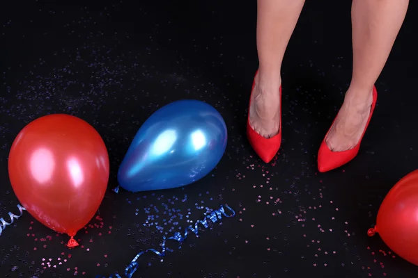 Piernas con confeti y globos en el suelo — Foto de Stock