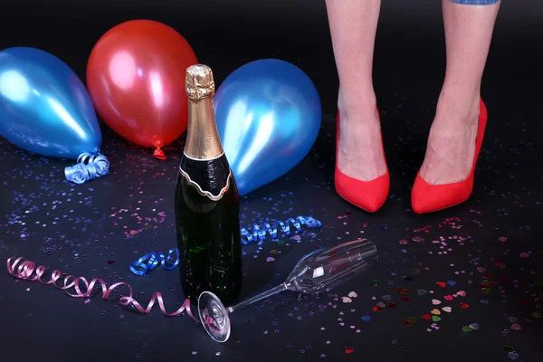 用五彩纸屑、 香槟和气球在地板上的双腿 — 图库照片