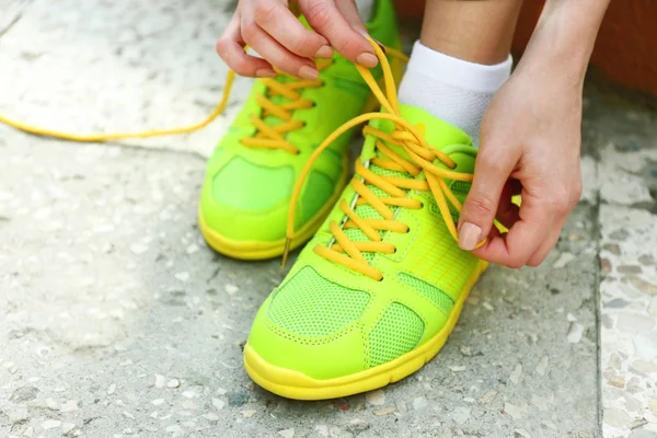 Mujer joven atando cordones afuera —  Fotos de Stock