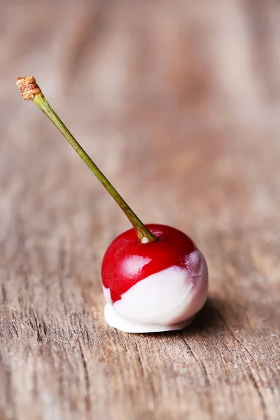 Cereja doce com chocolate, em fundo de madeira — Fotografia de Stock
