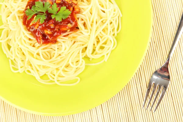 Italian spaghetti in plate on bamboo mat — Stock Photo, Image