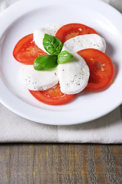 Caprese-Salat mit Mozarella, Tomaten und Basilikum auf Teller — Stockfoto
