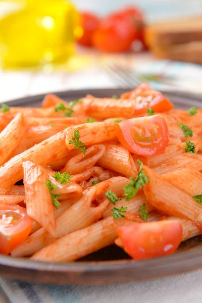 Pasta med tomatsås på tallriken på bordet — Stockfoto