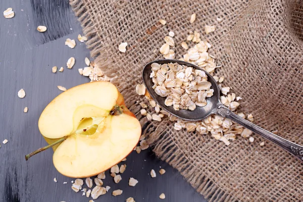 Apple with oatmeal and vintage spoon on sackcloth — Stock Photo, Image