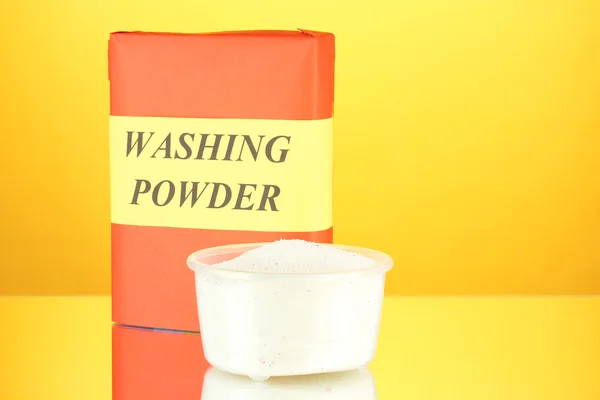 Box of washing powder with measuring cup — Stock Photo, Image