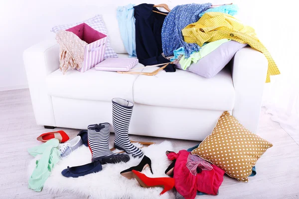 Messy colorful clothing on sofa — Stock Photo, Image