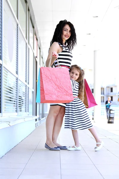Mutlu anne ve kızı ile alışveriş torbaları, açık havada — Stok fotoğraf