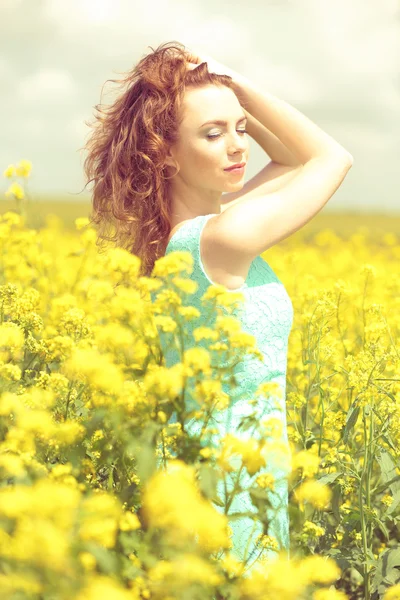 Beautiful young woman in flower field — Stock Photo, Image