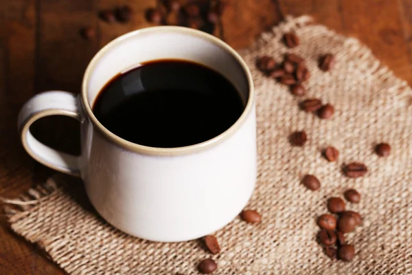 Cup met warme koffie op rouwgewaad servet — Stockfoto