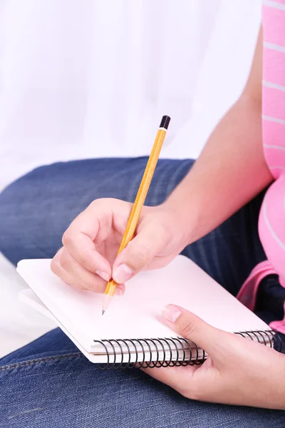 Closeup of young female student sitting on floor and studying — Stock Photo, Image