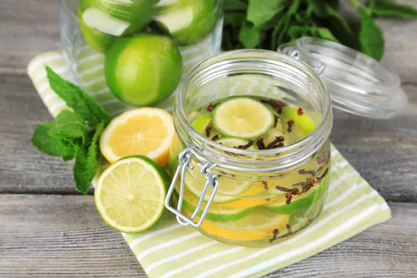 Pickled limes and cloves in glass jar — Stock Photo, Image