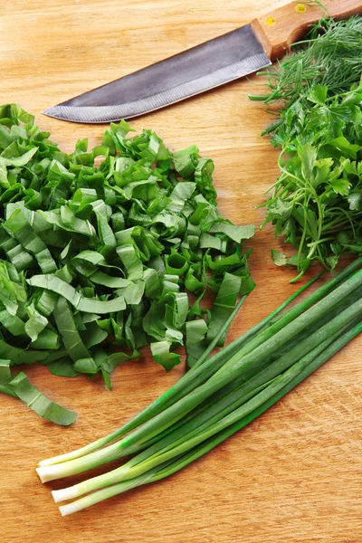 Verdes picados con cuchillo en tabla de cortar — Foto de Stock