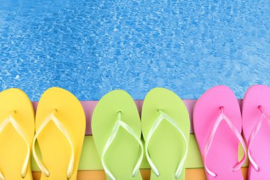 Deniz kenarında ahşap platform renkli flip flop