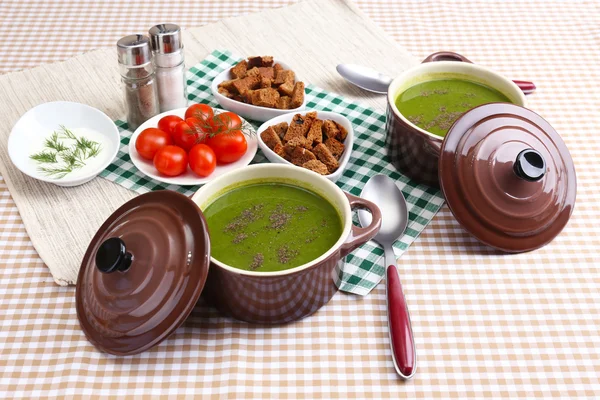 Sopa saborosa em panelas na toalha de mesa — Fotografia de Stock
